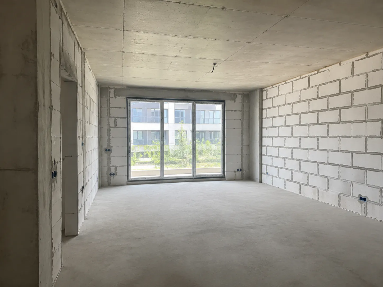 Unfinished living room shell with a wide window before redesign